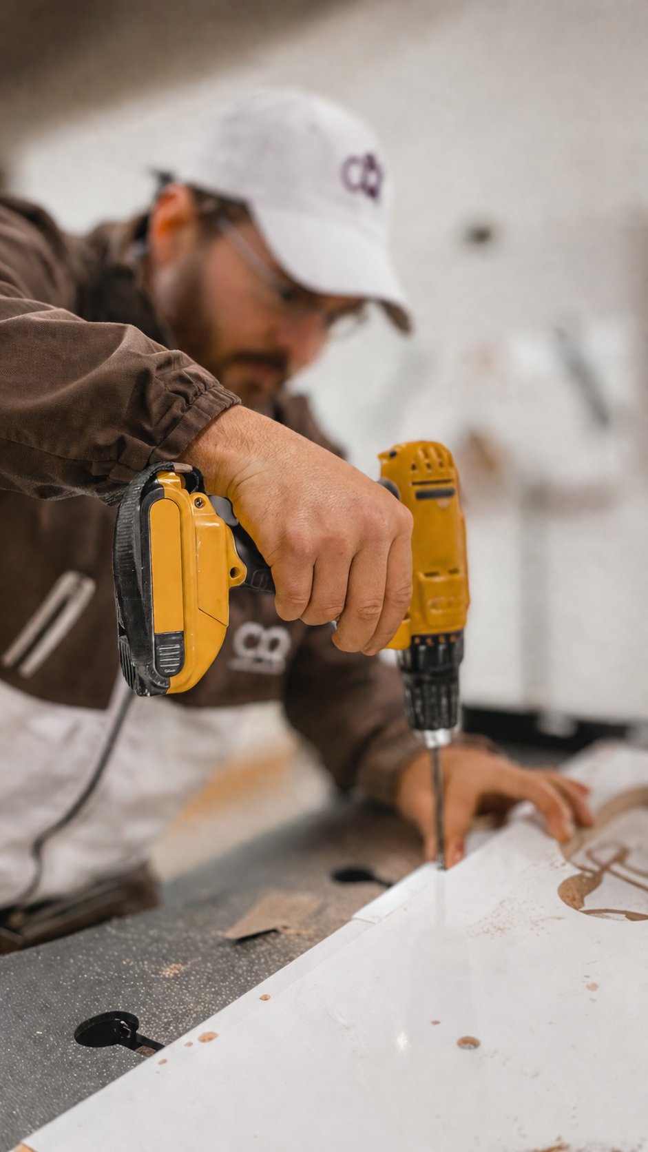 Installer using a cordless screwdriver on a furniture panel